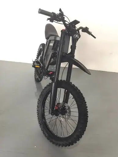 Black electric mountain bike front view with wide fat tires and disc brakes.