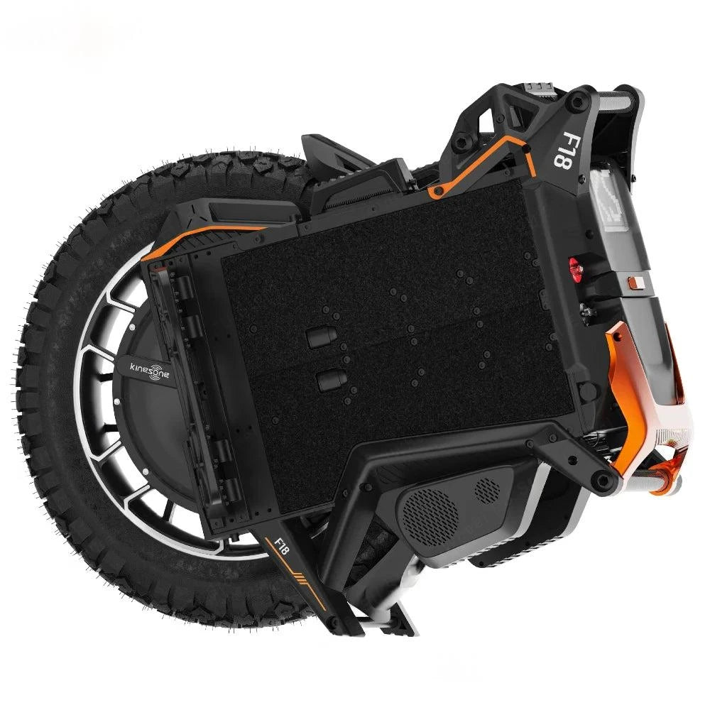 Electric unicycle angled side view with black textured body, knobby tire, orange trim around frame