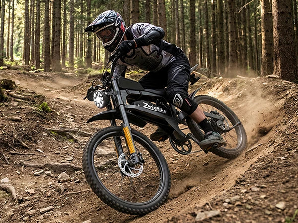 Rider on black electric dirt bike with knobby tires on a dirt path