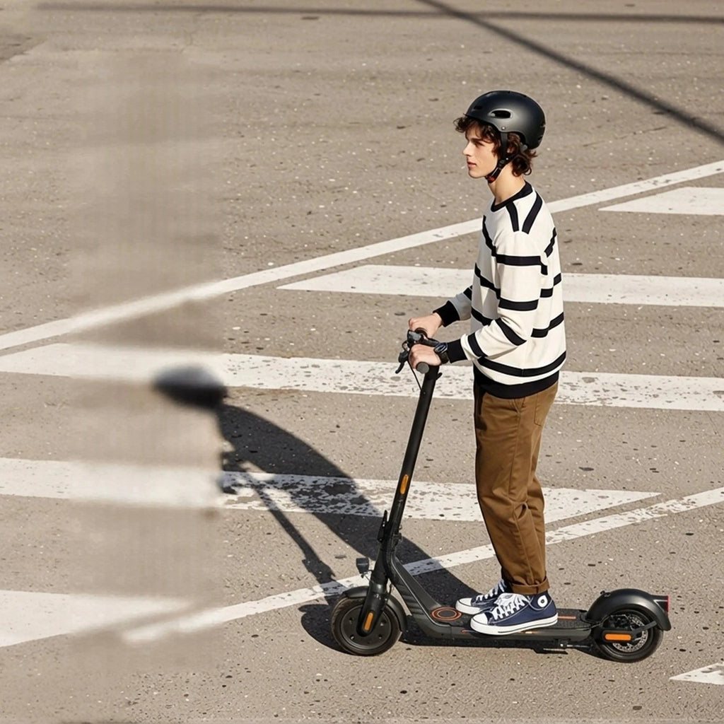 Rider on an electric scooter wearing a helmet and striped sweater