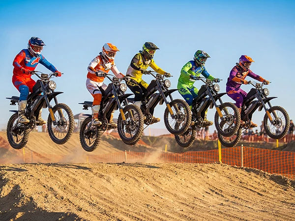 Group of riders on electric dirt bikes with helmets and knobby tires